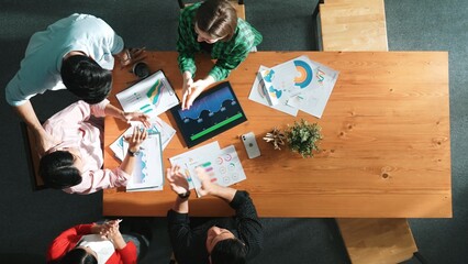 Naklejka premium Top down view of business woman explain and present financial chart. Group discuss and listen presentation about stock market statistic at meeting table with investment graph. Time lapse. Convocation.