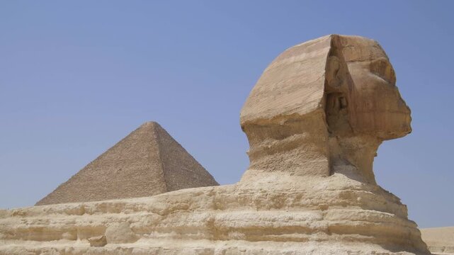 The Great Sphinx of Giza with the Pyramid of Khafre in the background under a clear blue sky, showcasing Egypt&rsquo;s iconic ancient monuments and timeless desert landscape.