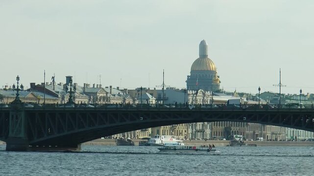 Saint Petersburg, Russia - August 29, 2022: Troitsky Bridge over the Neva River. Excursion boats carrying tourists sail along the river. The dome of St. Isaac's Cathedral is in the distance. Timelapse