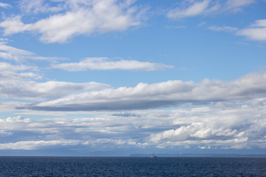 Calm Ocean Horizon With Boat Under Dramatic Cloudscape Near Tsawwassen, British Columbia, Canada