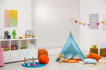 Beautiful wigwam with soft pillows, toys and stylish furniture in child's room © New Africa