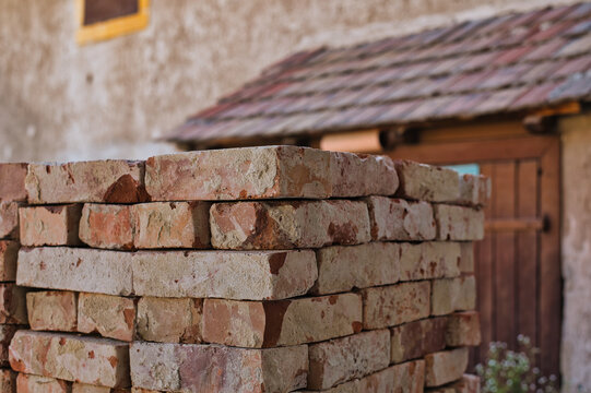 Old bricks pile with old building on background