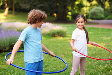 Cute kids exercising with hula hoops in park © New Africa