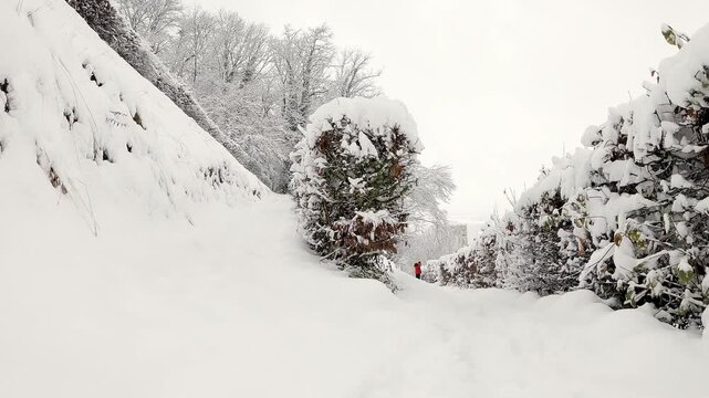 Man Climbs Deep Snowy Path Toward Camera In Winter