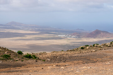 Naklejka premium Panoramic view of the island from the highest point of Lanzarote on the Famara cliff Lanzarote island in green in an unususaly rainy winter province of Las Palmas Canary islands Spain