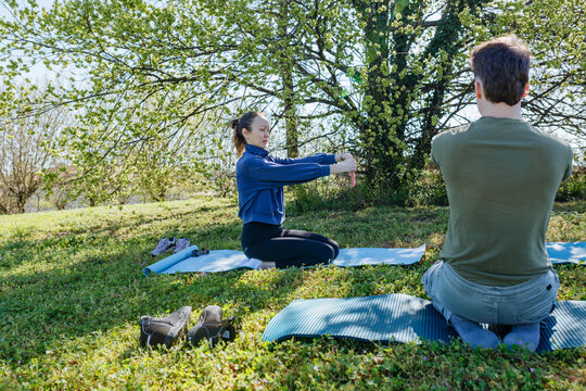 Friends Practicing Outdoor Yoga and Stretching Under Leafy Trees