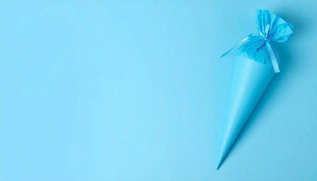 Blaue Zuckert&uuml;te auf hellblauem Hintergrund mit Textfreiraum zur Einschulung und zum Schulanfang