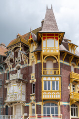 Fototapeta premium Houses of Mers-les-Bains, seaside town with 19th-century sea-bathing villas with colorful wooden balconies and white chalk cliffs, tourists destination in France