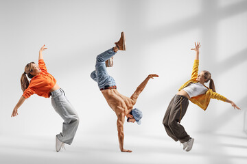 Obraz premium Guy performing handstand and two girls dancing