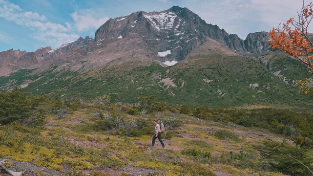 Side view of person walking the W Trek in Torres del Paine with an epic mountain view in the distance, Patagonia, Chile