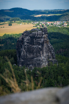 Falkenstein sandstone cliff overlooking fields and forest in Saxon Switzerland
