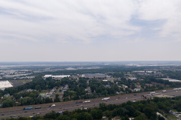 Fototapeta premium Aerial view of multi-lane highway traffic near suburban residential and industrial areas
