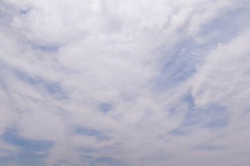 Fototapeta premium White wispy clouds covering blue sky in daytime