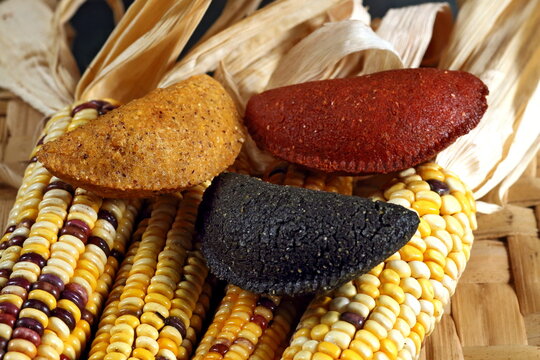 Cornmeal mush pastry served on ears of corn of various colors.