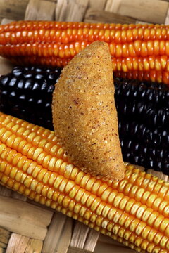 Cornmeal mush pastry served on ears of corn of various colors.