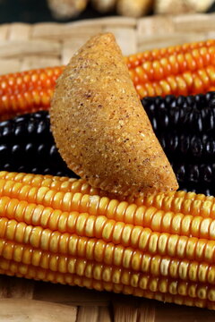 Cornmeal mush pastry served on ears of corn of various colors.