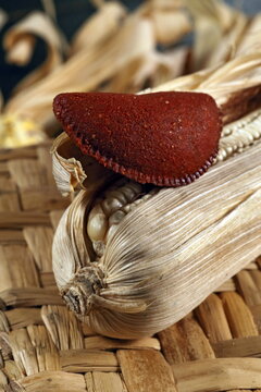 Cornmeal mush pastry served on ears of corn of various colors.
