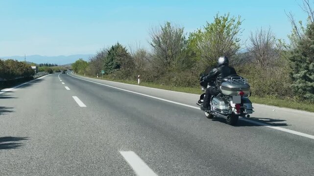 Traveler Motor Biker Rides Cruiser Motorcycle on Scenic Highway