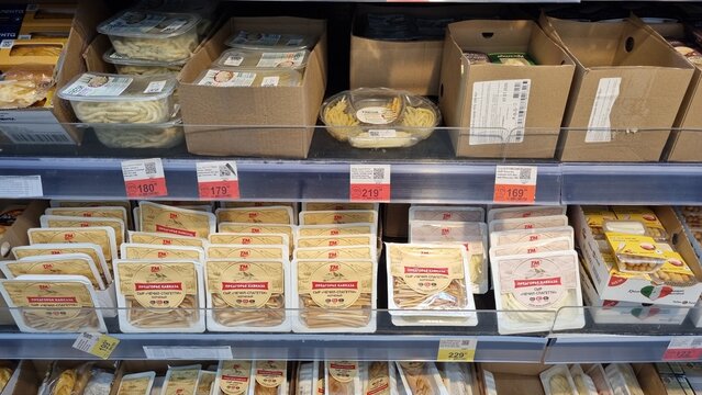 Packaged string cheese and savory cheese snacks on supermarket shelf