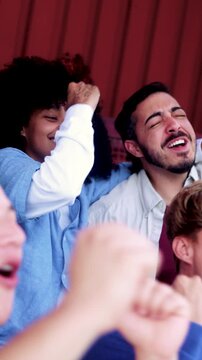 Latin sport fans celebrating with crowd team with stadium background - People cheering soccer championship games at world event competition - Vertical video