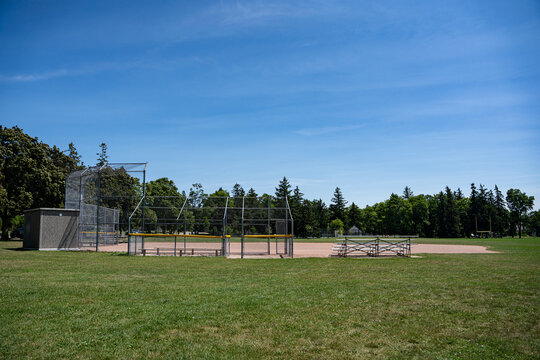 Empty community baseball field under blue sky.