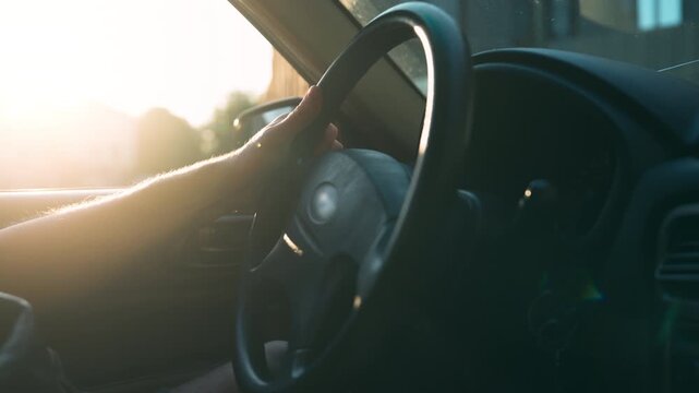 Wide Shot of Male Driver Hand Tapping on Steering Wheel While Waiting | Frustrated Commuter in Car Interior During Boredom | Stressful Daily Drive at Sunset