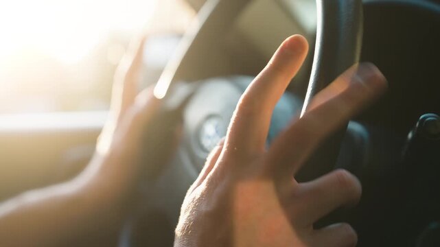 Close-Up of Both Male Hands Drumming Impatiently on Steering Wheel | Frustrated Driver Waiting in Car Interior with Golden Sunlight Glow | Stressful Driving Emotions