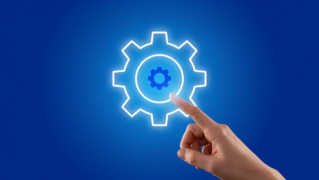 Gear icon with a hand touching it glowing on a blue background
