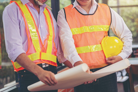 Structural engineer and architect and foreman worker with blueprints discuss, plan working for the building construction site office. Construction collaboration concept