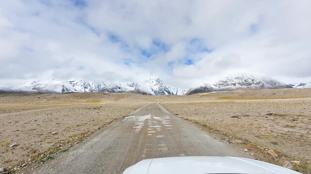 Driving on the off-road way to Ama Drime Snow Mountain in Shigatse, Tibet, China, the rutted mud road full of deep muddy craters and horribly bumpy. POV from car, 4k fast motion footage travel concept
