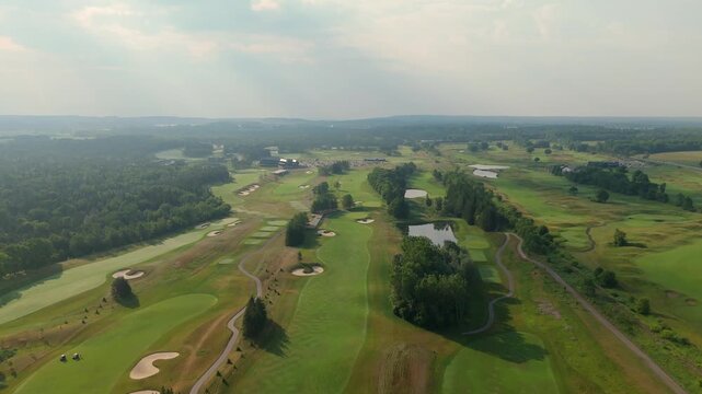 Aerial view of a vast golf course with manicured greens, fairways and sand traps.