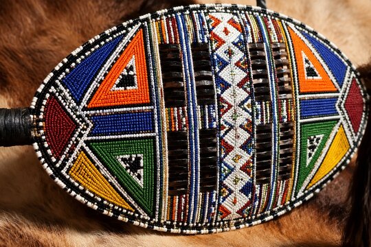Traditional Zulu shield with vibrant, symmetrical beadwork, cultural artifact.