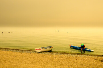 Obraz premium Paddleboarder Under Smoky Golden Sky