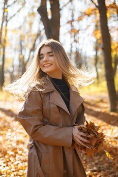 Portrait of a young woman posing for a photo in autumn park