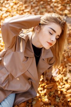 Portrait of a young woman posing for a photo in autumn park