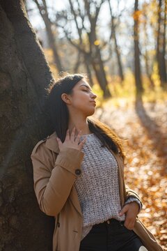 Portrait of a young woman posing for a photo in autumn park