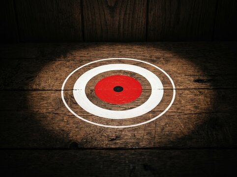 Target on wooden background with spotlight.