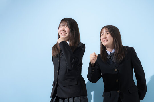 水色背景で未来や将来へ向かって走る、歩く日本人女子高生や中学生の上半身　2人で前向きに進む受験や青春、合格やオープンキャンパスイメージ