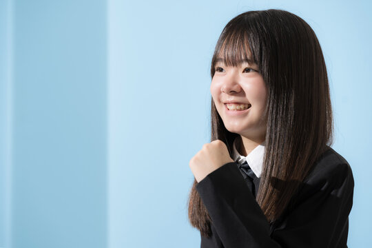 水色背景で未来や将来へ向かって歩く日本人女子高生や中学生上半身　前向きに進む受験や青春イメージクローズアップ