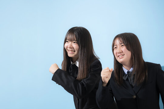 水色背景で未来や将来へ向かって走る、歩く日本人女子高生や中学生の上半身　2人で前向きに進む受験や青春、合格やオープンキャンパスイメージ