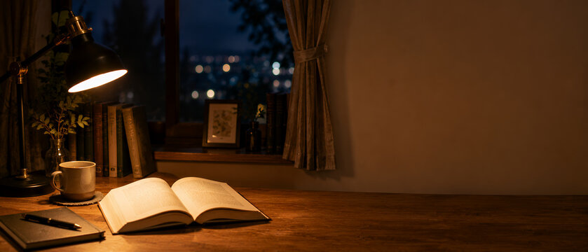 夜のデスクで本を読む静かな読書時間　秋の読書週間イメージ