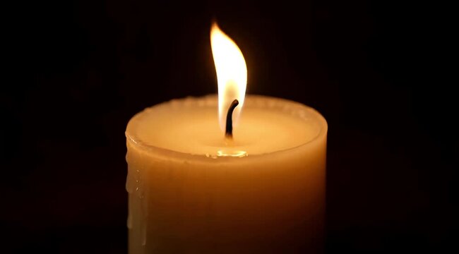 Cozy warm candle flame light in dark ambiance perfect for relaxation and meditation atmosphere
