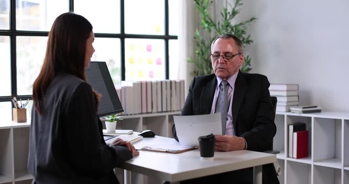 Young businesswoman attending a job interview, holding a document while a male recruiter reviews applicants on a clipboard, signifying human resources, career planning, and new employment