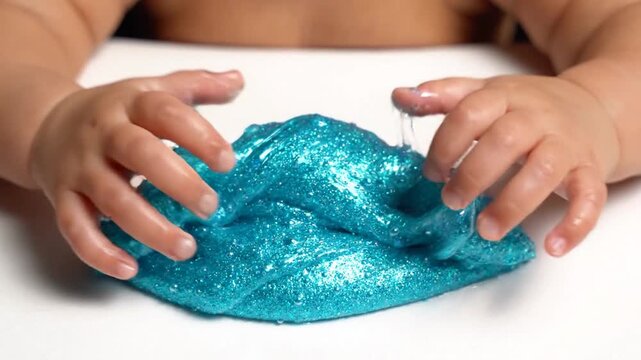 Baby Hands Playing with Glittery Blue Slime