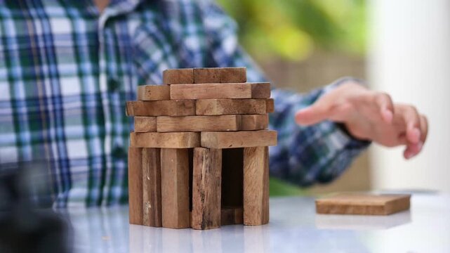 kid playing with wooden bricks. Children constructing house from colored elements. Bright toy building - real estate theme.