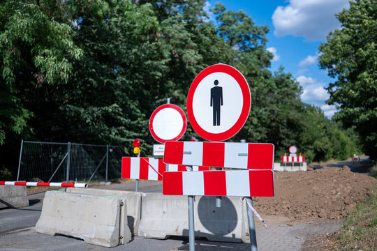 Znaki zakazu ruchu oraz zakazu ruchu pieszych blokujące wstęp do remontowanego odcinka drogi odgrodzone betonowymi barierkami uniemożliwiającymi przejazd w porze letniej w zachodniej Polsce
