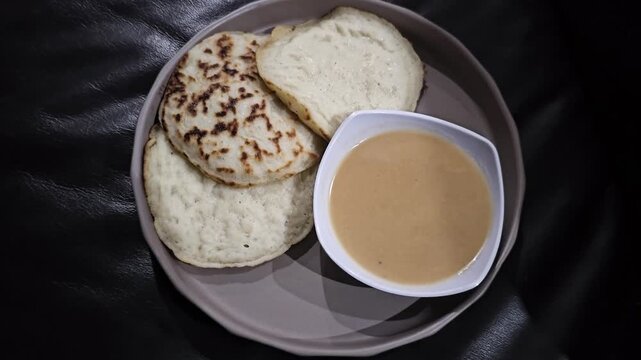cup of cappuccino,Serabi or Surabi traditional Indonesian pancake served with palm sugar sauce,made from rice flour and coconut milk.Popular for break fasting ,Eid mubarak celebration and ceremony