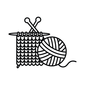 A ball of yarn and knitting needles on a partially knitted fabric