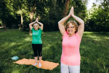 Senior women enjoying outdoor yoga for wellness and fitness © Maria Vitkovska