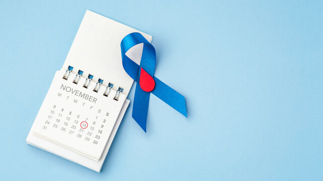 Diabetes Day concept, Blue ribbon with a red blood drop with calendar over a light blue background with copy space